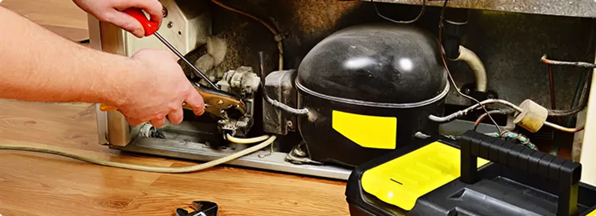 Refrigerator repair technician fixing the compressor and wiring in Wadesville, IN