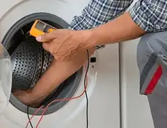 Washing machine repair technician testing a front-load washer with diagnostic tools in Evansville, IN
