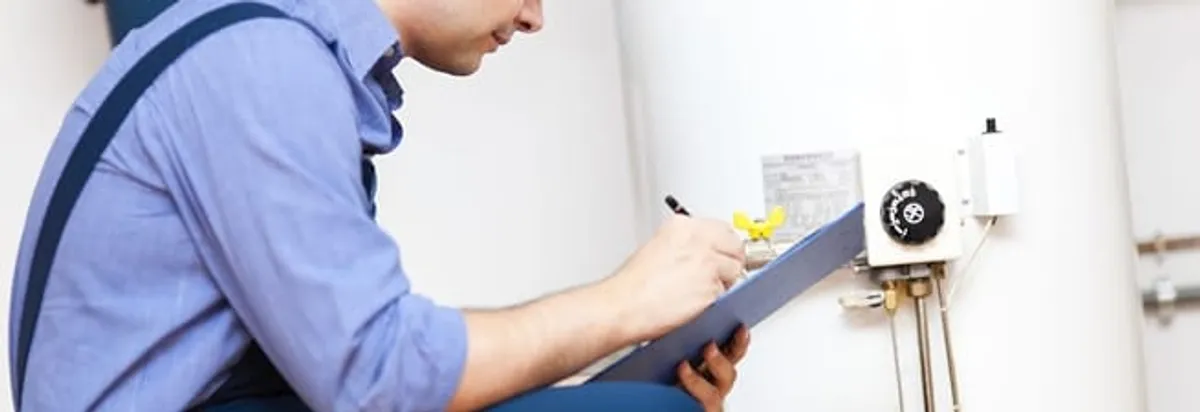 Water heater repair technician inspecting the unit and recording service notes in Evansville, IN